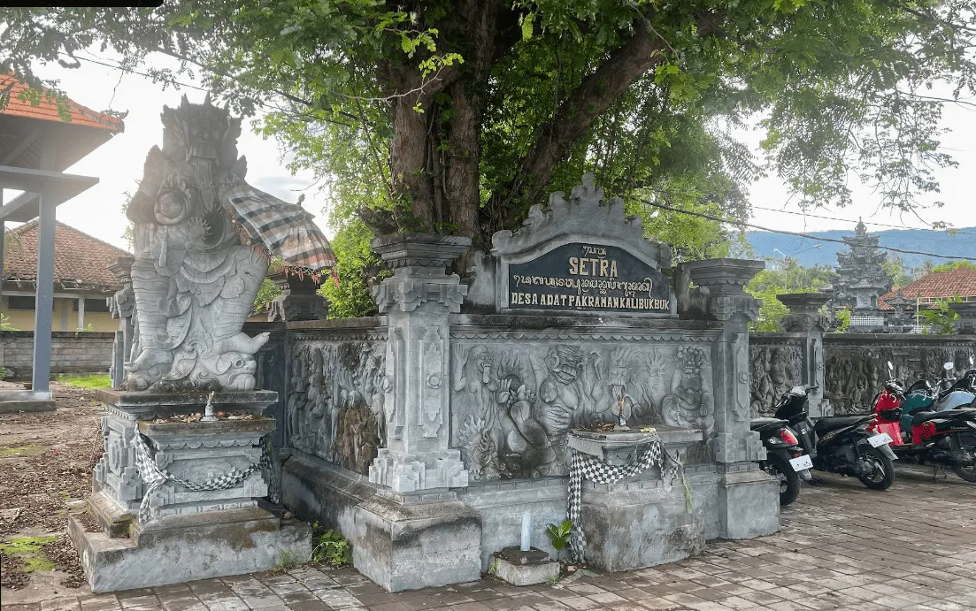 Fotografie balijského hřbitova umístěného hned u parkoviště na pláži Lovina na severu Bali. Tradiční kamenné stavby, které si turisté často pletou s chrámem.