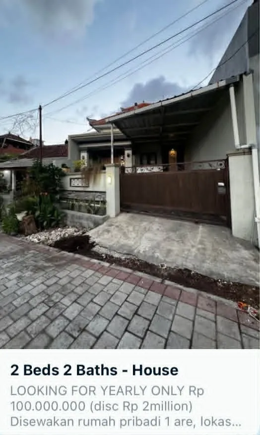Screenshot online inzerátu na dlouhodobý pronájem domu na Bali. Nabídka ukazuje dům se 2 ložnicemi a vjezdovou bránou za cenu 100 milionů indonéských rupií ročně.