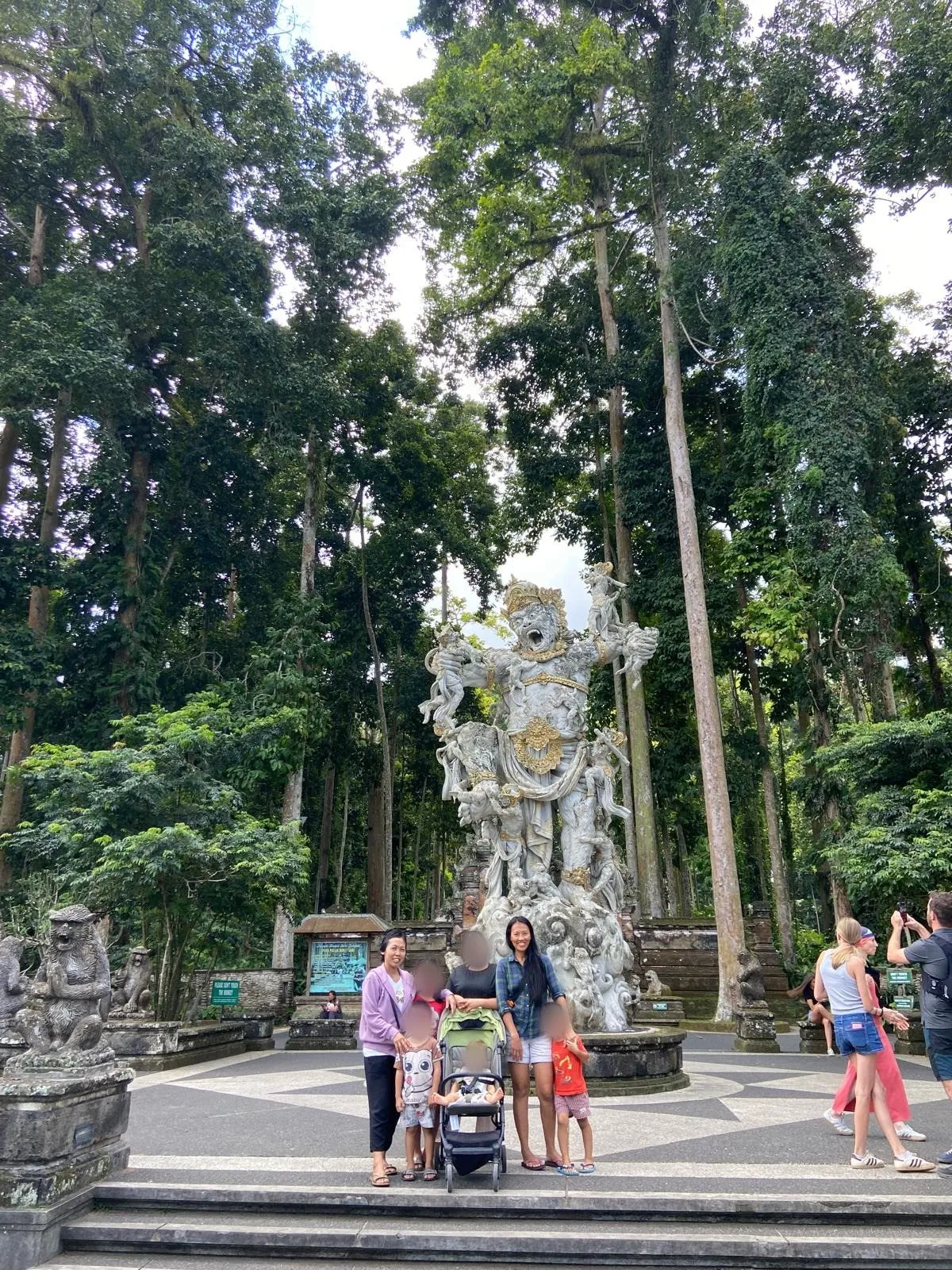 Rodina u sochy opičího generála Hanumana před vstupem do opičího lesa Sangeh na Bali
