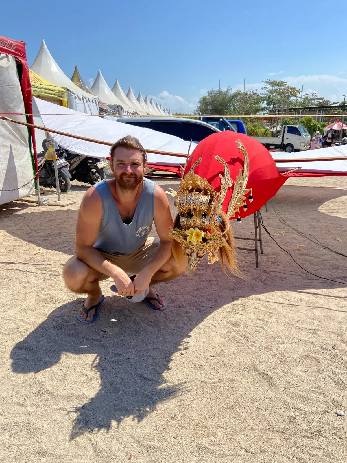 Autor článku v podřepu u hlavy balijského draka janggan na festivalu v Sanuru