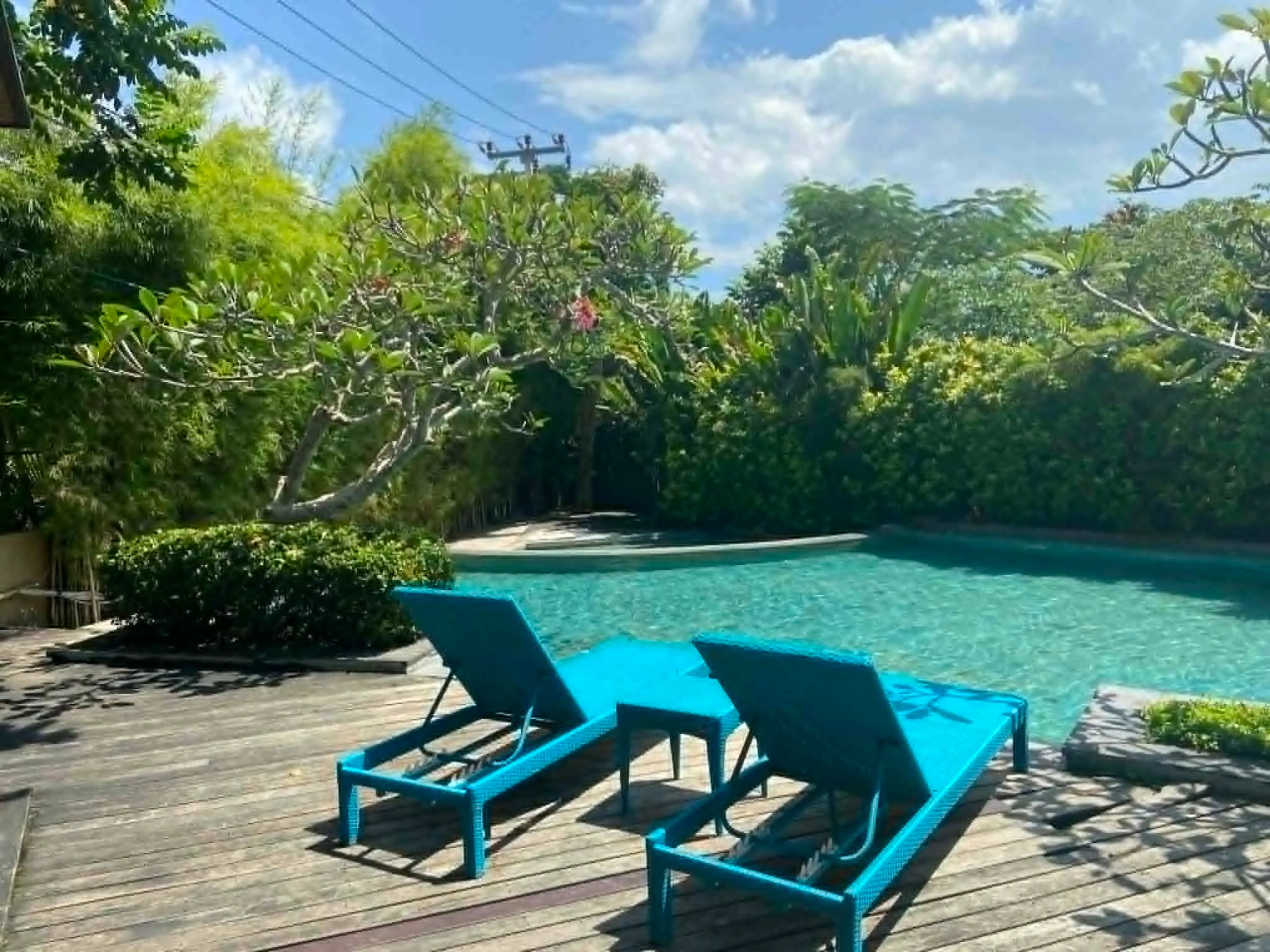 Koláž pěti fotografií z pronajatého domku v rezidenci Royal Garden na Nusa Dua, Bali. Zobrazuje sdílený bazén s lehátky, vjezd s autem a čistý interiér obývacího pokoje a dvou ložnic.